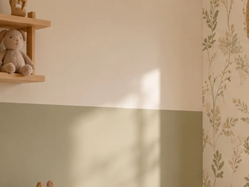Halfhoge saliegroene wand onder gebroken wit, met een wandplankje en bloemetjesbehang